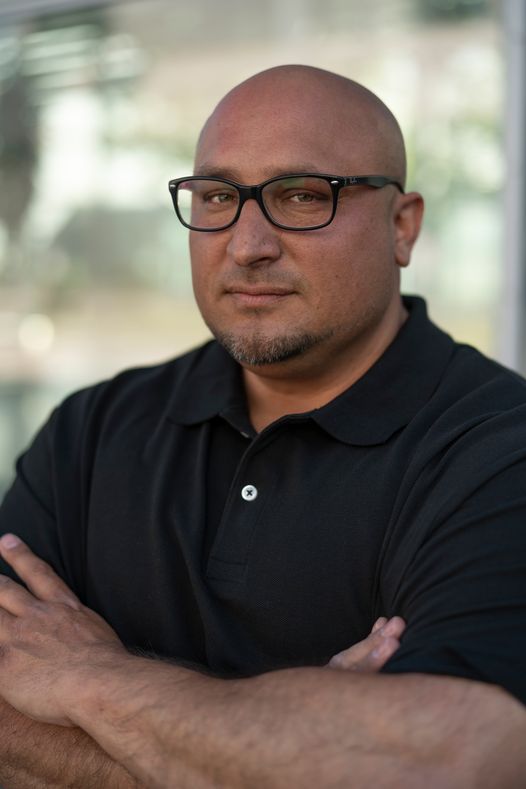 David Mirga, KI-Manager und Buchautor, im Business-Casual-Look mit verschränkten Armen